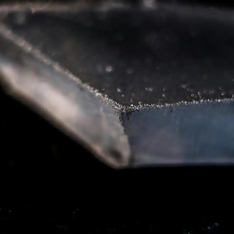 5-axis laser cutting head creating a 45-degree V-bevel on thick steel for weld preparation